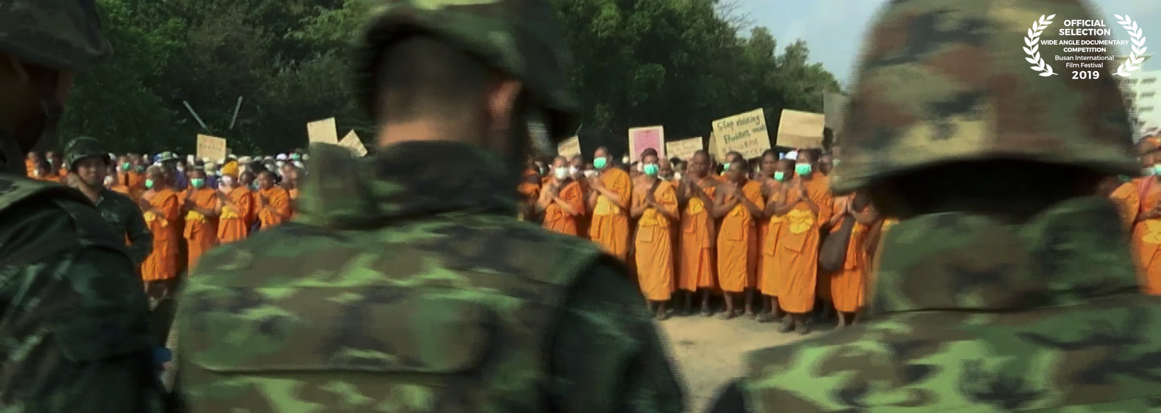 Buddhist monks holding placards in front of military - Come and See - THIS Buddhist Film Festival