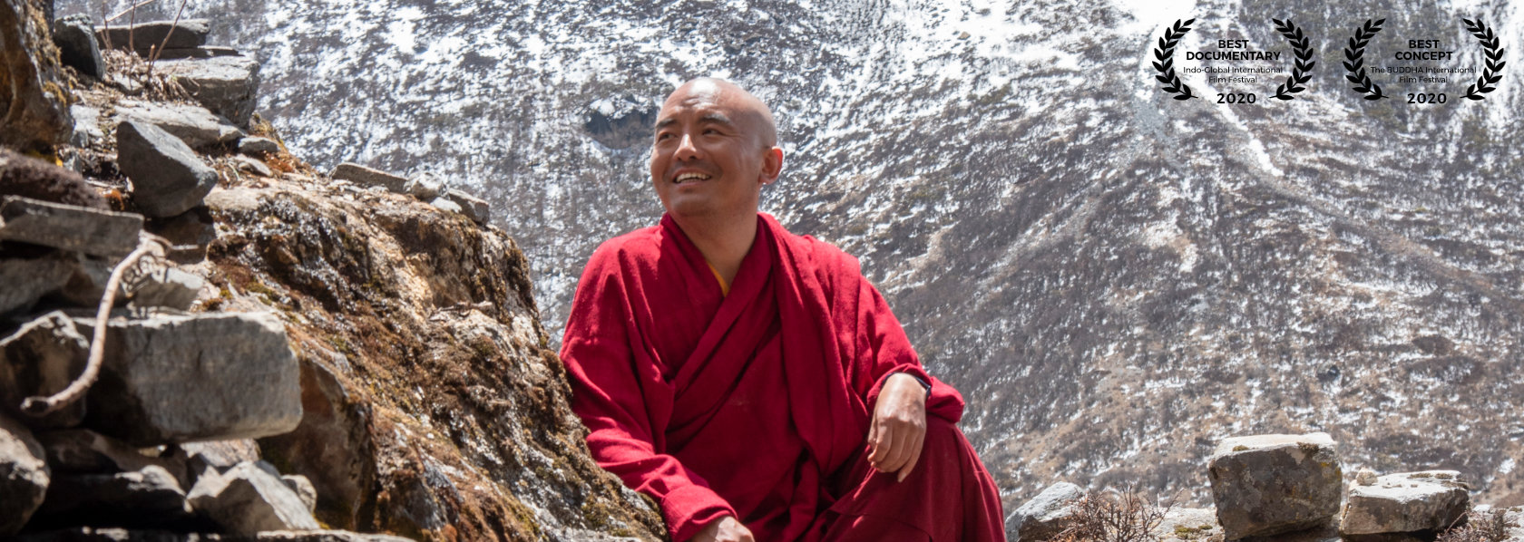 Mingyur Rinpoche smiling looking to his right sitting with one knee up winter mountain background - Wandering But Not Lost - THIS Buddhist Film Festival