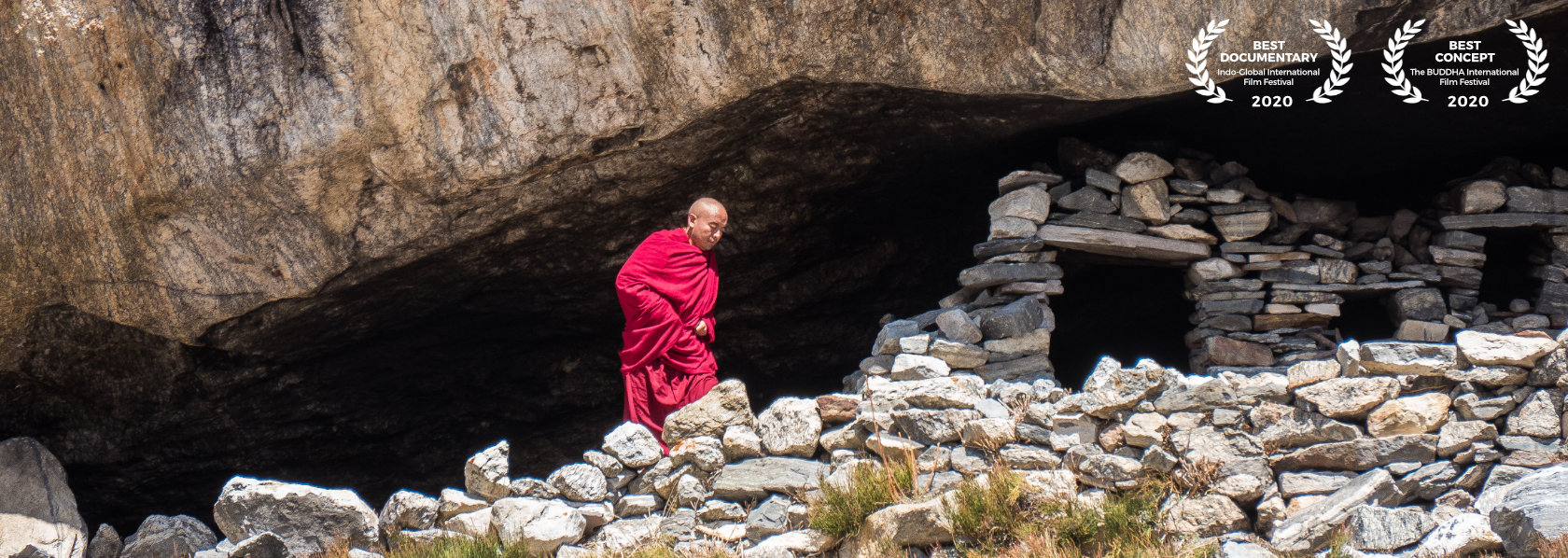 Mingyur Rinpoche walking beside a mountain with stones - Wandering But Not Lost - THIS Buddhist Film Festival